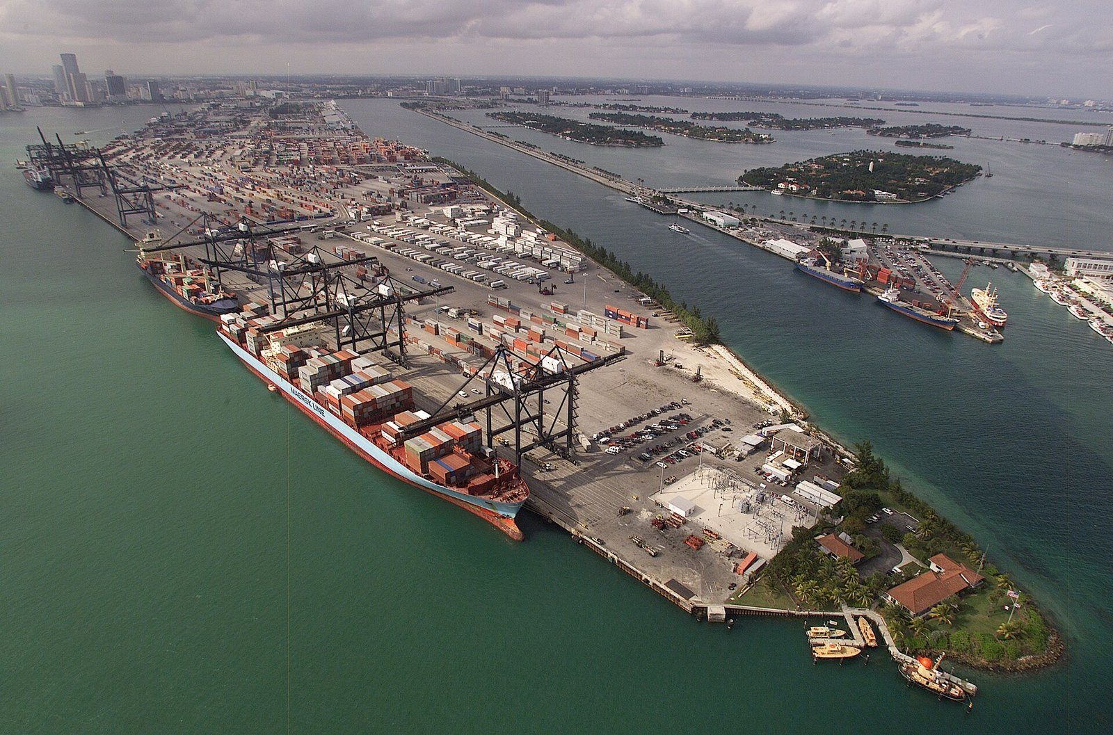 Vista aérea de la terminal de contenedores del Puerto de Miami, con grúas pórtico, un buque portacontenedores atracado y pilas de contenedores